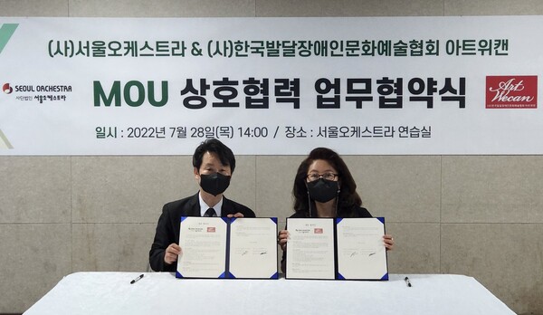 아트위캔 왕소영 대표(오른쪽)와 서울오케스트라 김희준 단장이 상호협력 업무협약을 체결한 뒤 포즈를 취하고 있다. Ⓒ아트위캔 제공
