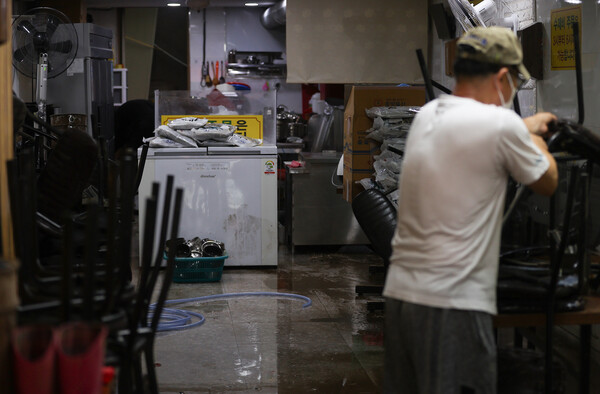 9일 폭우로 침수피해를 입은 서울 동작구 남성사계시장의 한 상인이 침수된 가게를 정리하고 있다. 사진=연합뉴스